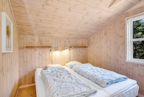 A wooden-paneled room with two beds, a window, and wall-mounted lights. - Bright holiday home with electric charger, terrace and wood-burning stove (Fjerritslev)