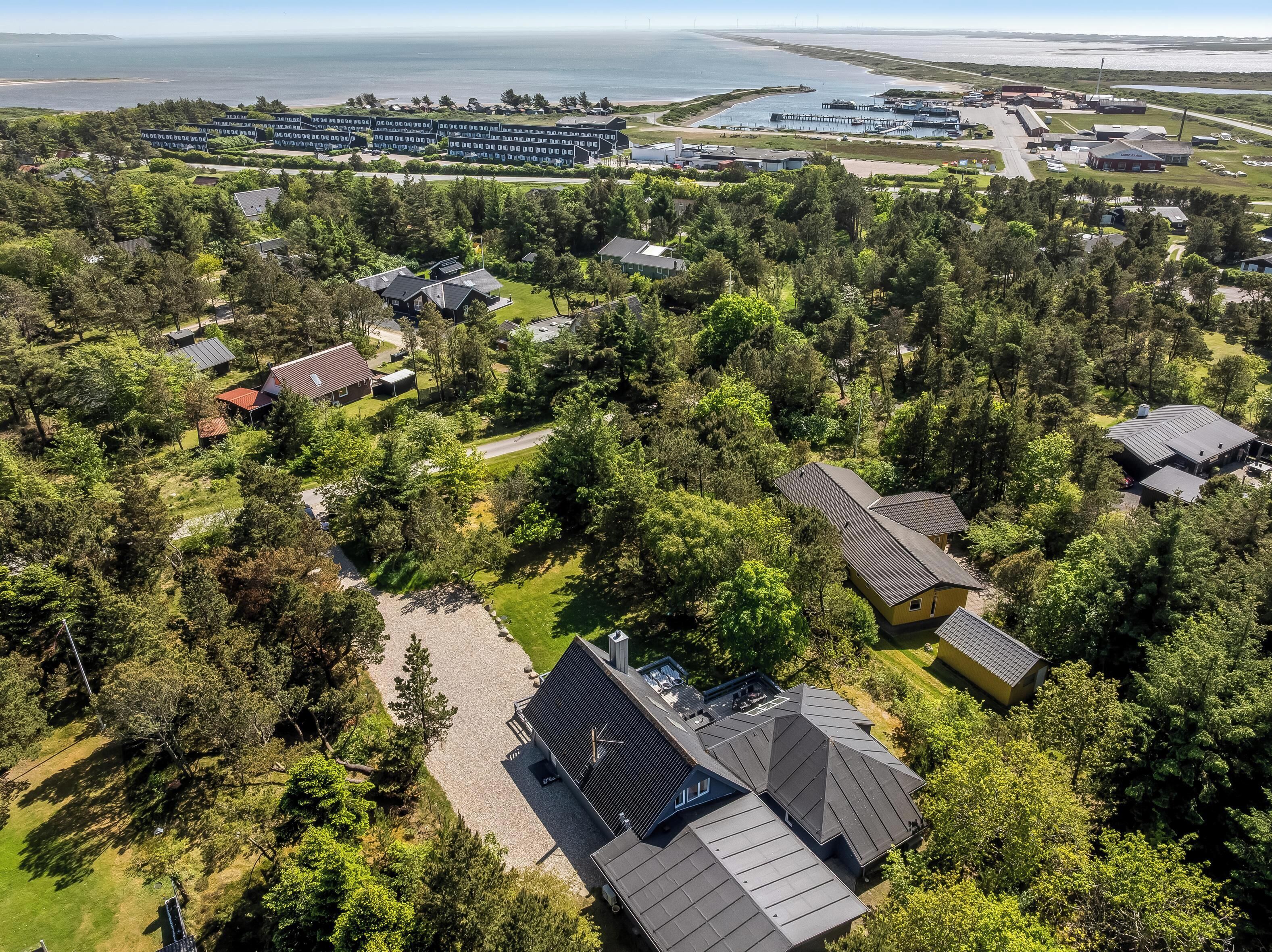 An aerial view of a residential area with houses, a marina, and a large building complex.