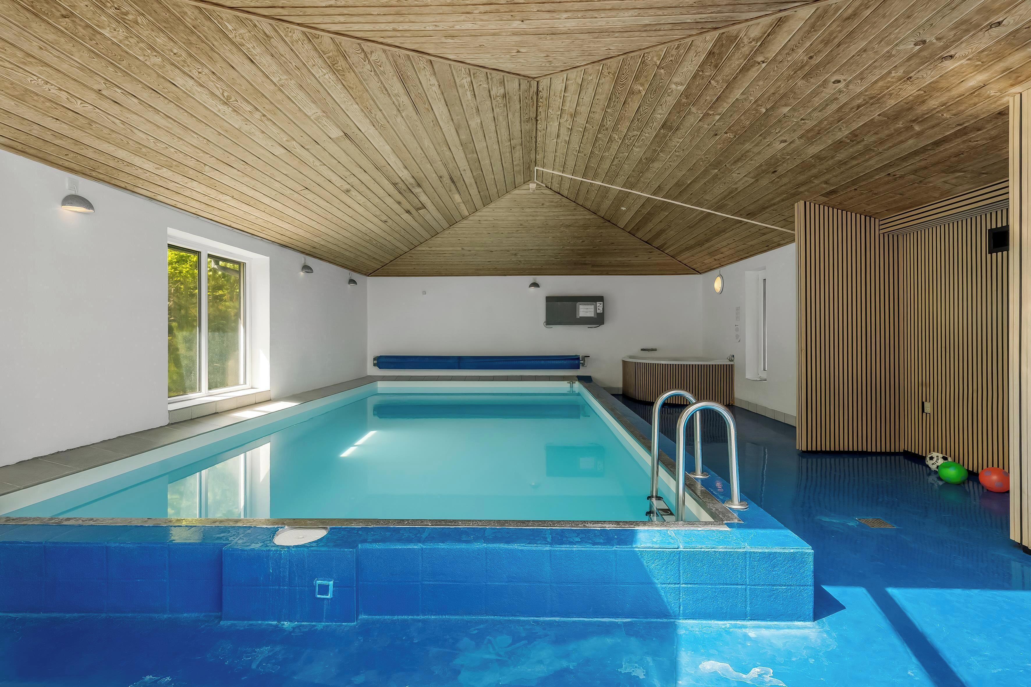A swimming pool with a wooden ceiling and a window on one side.