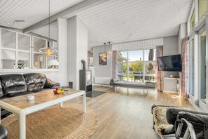 Ein modernes Wohnzimmer mit Sofa, Couchtisch und Fernseher.