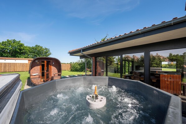 Ein Whirlpool mit Holzfass und einer überdachten Terrasse.