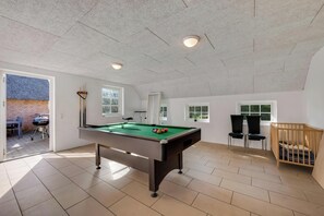 Ein geräumiges Zimmer mit Billardtisch, Reisebett und Blick ins Freie.
