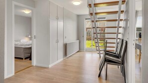 A modern interior with a wooden floor, white walls, a bed, a radiator, and a view of the outdoors. - 14-person holiday home in Agger with wilderness bath and outdoor sauna (Vestervig)
