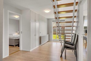 A modern interior with a wooden floor, white walls, a bed, a radiator, and a view of the outdoors. - 14-person holiday home in Agger with wilderness bath and outdoor sauna (Vestervig)