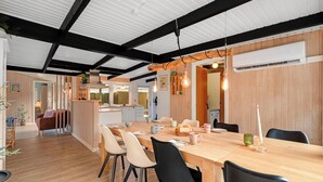 Une cuisine moderne avec des meubles en bois, un îlot central et des luminaires suspendus.