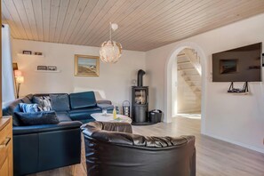Un salon moderne avec un canapé, une table basse et une cheminée.