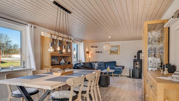 Ein modernes Wohnzimmer mit Essbereich, Holzboden und Blick ins Freie.