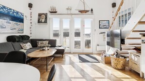 Un salon moderne avec un canapé, une table basse et un téléviseur.