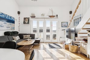 Ein modernes Wohnzimmer mit einer Couch, einem Couchtisch und einem Fernseher.