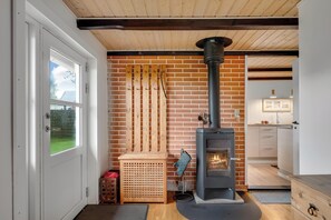Ein Zimmer mit Backsteinwand, Holztür, Kamin und Küchenzeile.