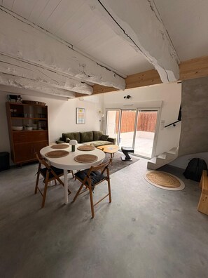 Un intérieur moderne comprenant une table à manger, des chaises, un canapé et un escalier.