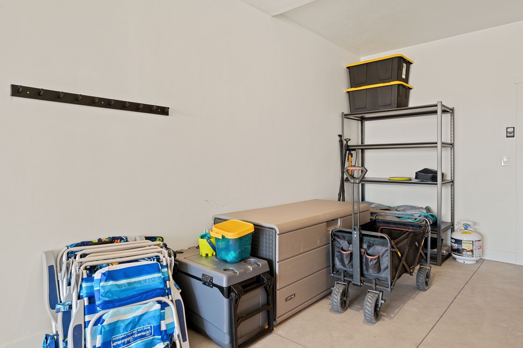 A storage area with shelves, a cart, and a portable storage unit.