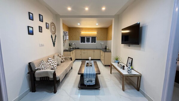 A living room with a sofa, coffee table, and a TV.