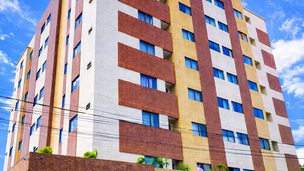 Un hôtel à plusieurs étages, doté d’un design moderne, avec une façade combinant des éléments en brique et en verre, et une entrée bien visible avec une enseigne.