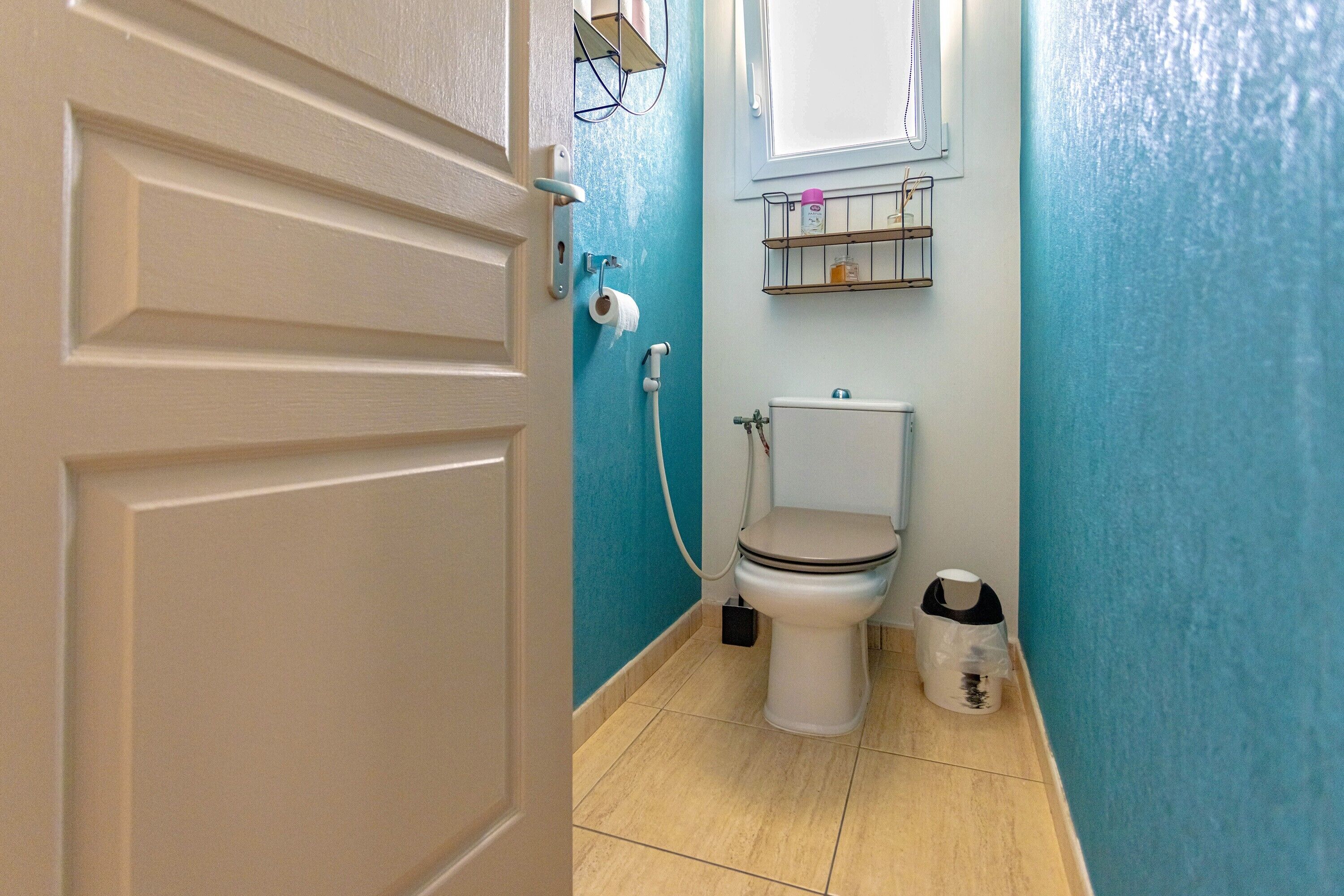 A bathroom with a toilet, a bidet, and a trash bin.
