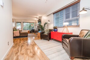 A modern living room with a fireplace, leather sofas, and a red cabinet. - Vancouver home, 10 minute drive to downtown. Close to Skytrain, parking included (Vancouver)