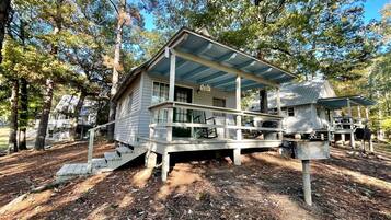 A cabin with a porch, a small deck, and a covered area.