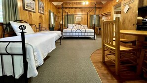 Ein Zimmer mit zwei Betten, einem Holztisch und einem Kamin.