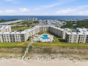 Ein Resort mit einem zentralen Pool, mehreren Gebäuden und Blick auf den Ozean.