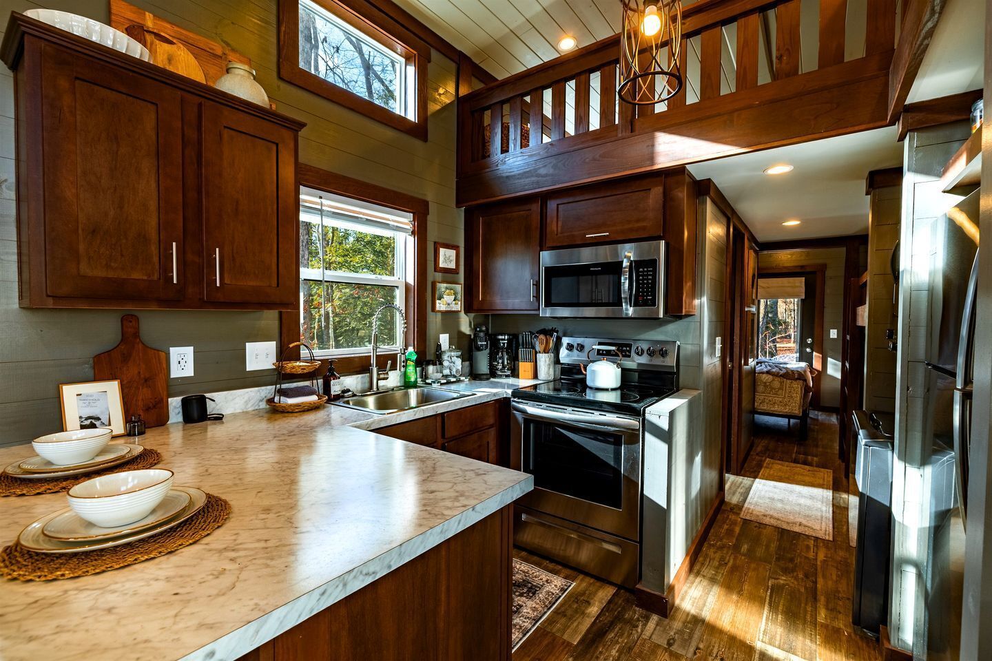 A kitchen with wooden cabinets, a stainless steel stove, and a microwave.