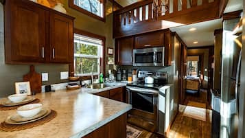 A kitchen with wooden cabinets, a stainless steel stove, and a microwave.
