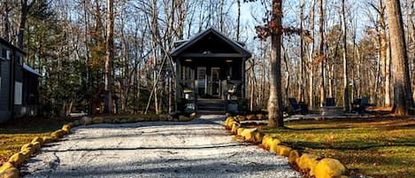 A lodge with a gravel driveway leading to a covered entrance, surrounded by trees.