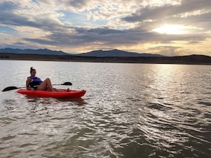 A person kayaking on a calm body of water with mountains in the background. - Unique Mirror Pod on the Shores of Yuba Lake for a Fantastic Couples Escape in Utah (Levan)