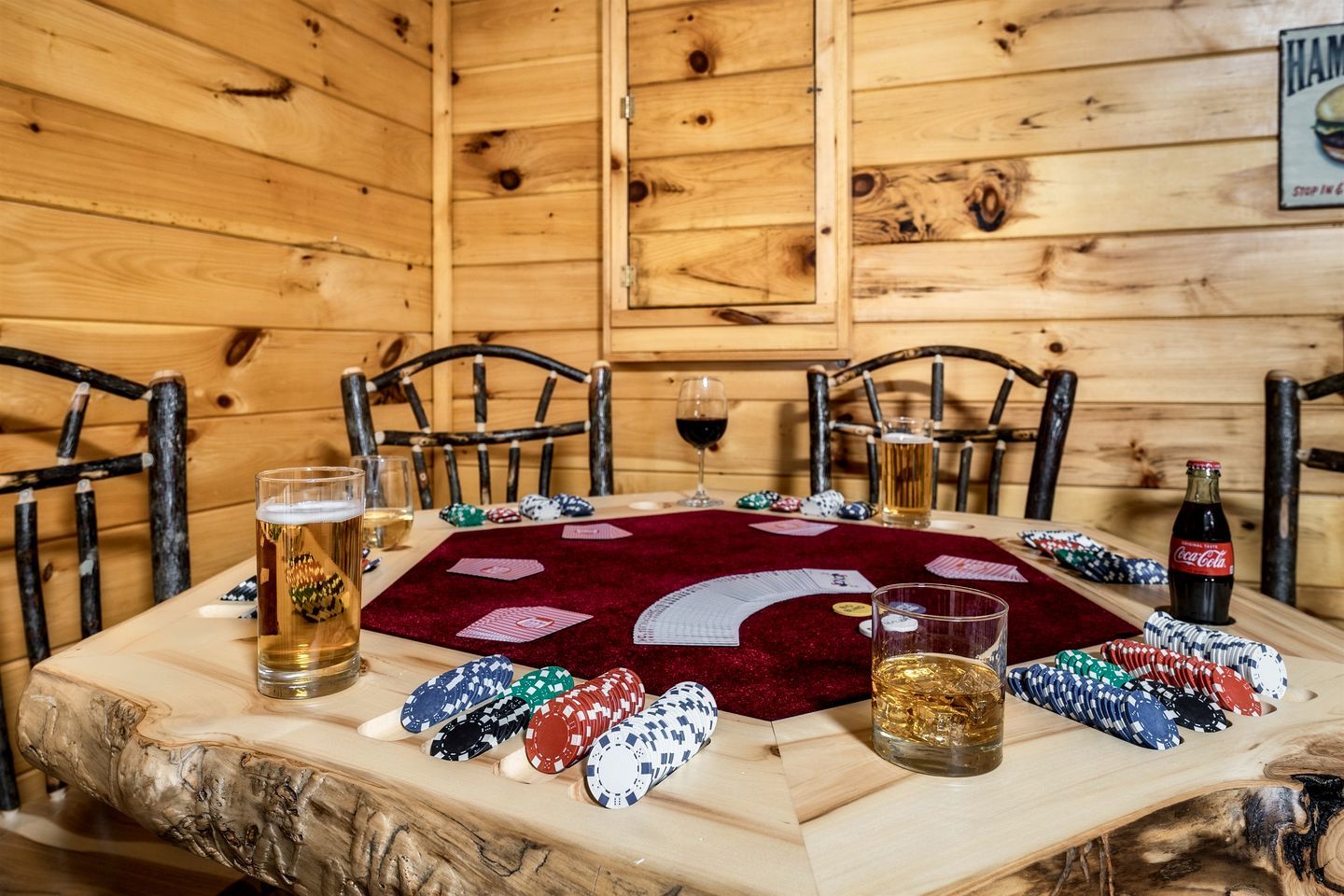Un interior de madera con una mesa de póker, sillas y fichas de juego.