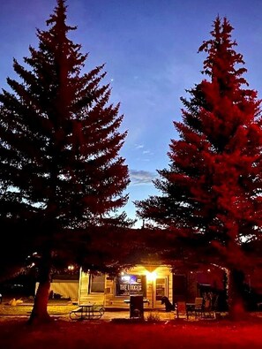Un bâtiment sur lequel on peut lire, sur une enseigne, les mots « THE LOBES », la nuit, et qui est entouré de grands arbres.