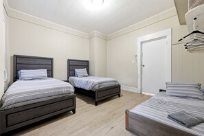Un dormitorio con dos camas individuales, un armario y una puerta.
