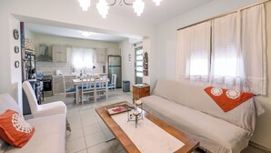 Uma sala de estar com sofá, mesa de centro e um espaço de jantar com cadeiras e mesa.