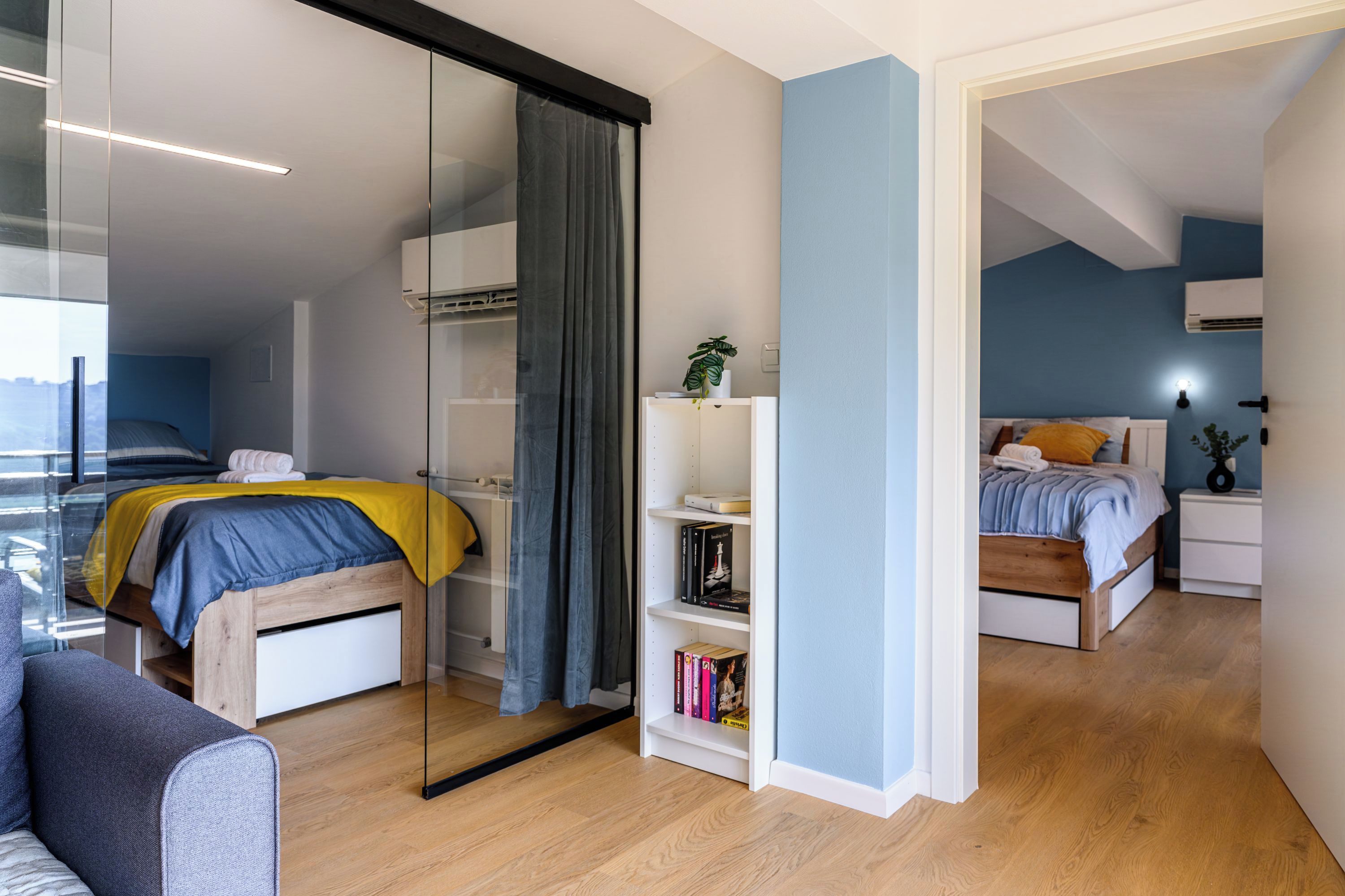 Un dormitorio moderno con cama, mesita de noche y estantería.