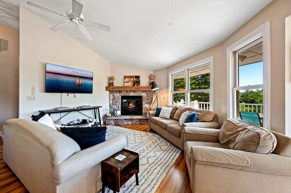 A living room with a fireplace, a television, and a sofa. - Design Cabin with Jacuzzi and Porch in Sister Bay, Wisconsin (Sister Bay)