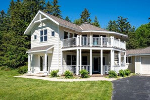 A two-story house with a balcony, a covered porch, and a garage. - Design Cabin with Jacuzzi and Porch in Sister Bay, Wisconsin (Sister Bay)
