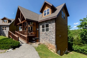 A lodge with a stone facade, wooden deck, and a covered porch. - Wonderful Cabin with Game Room and Swimming Pool in Branson, Missouri (Branson)