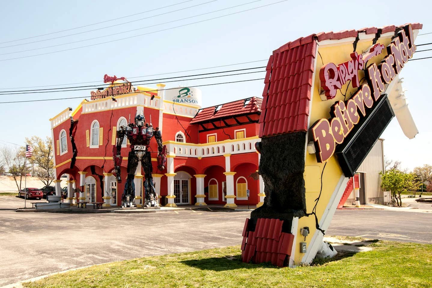 A building with a red facade, a large sign reading 'Ripley's Believe It or Not!', and a large robot figure in front.