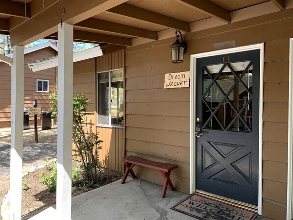 A wooden exterior with a dark door, a bench, and a sign reading 'Dream Weaver.' - Charming Pet Friendly Studio Cabin near Metcalfe Bay, Big Bear, California (Big Bear Lake)