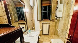 A bathroom with a sink, mirror, bathtub, and shower. - Bnb Fantasia (Bologna)