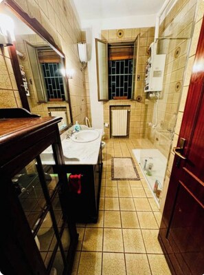 A bathroom with a sink, mirror, bathtub, and shower. - Bnb Fantasia (Bologna)