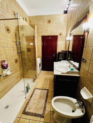 A bathroom with a glass shower enclosure, a sink, a mirror, and a toilet. - Bnb Fantasia (Bologna)