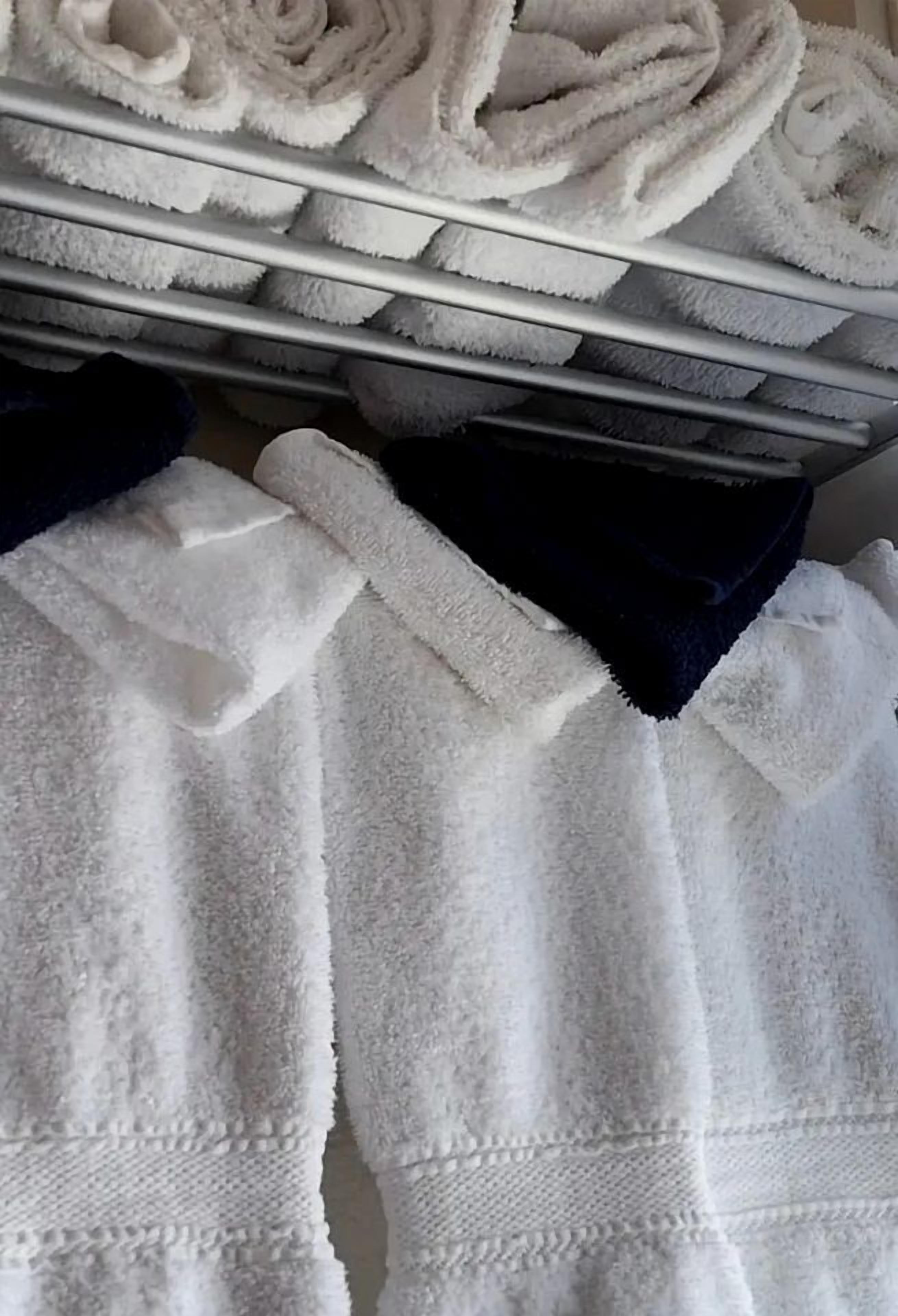 Een rek met opgevouwen handdoeken in een hotelkamer.
