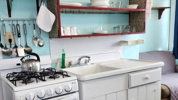 Une cuisine compacte équipée d’une cuisinière, d’un four, d’un évier et d’un four à micro-ondes.