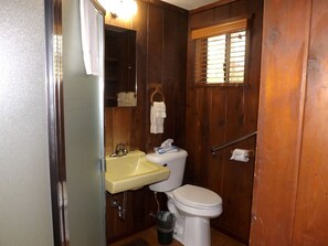 Ein kleines Badezimmer mit Waschbecken, Toilette und Fenster.