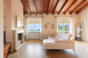 Una sala de estar con chimenea, un sofá y vistas amplias a través de grandes ventanales.