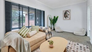 Een moderne woonkamer met een bank, een salontafel en een groot raam.