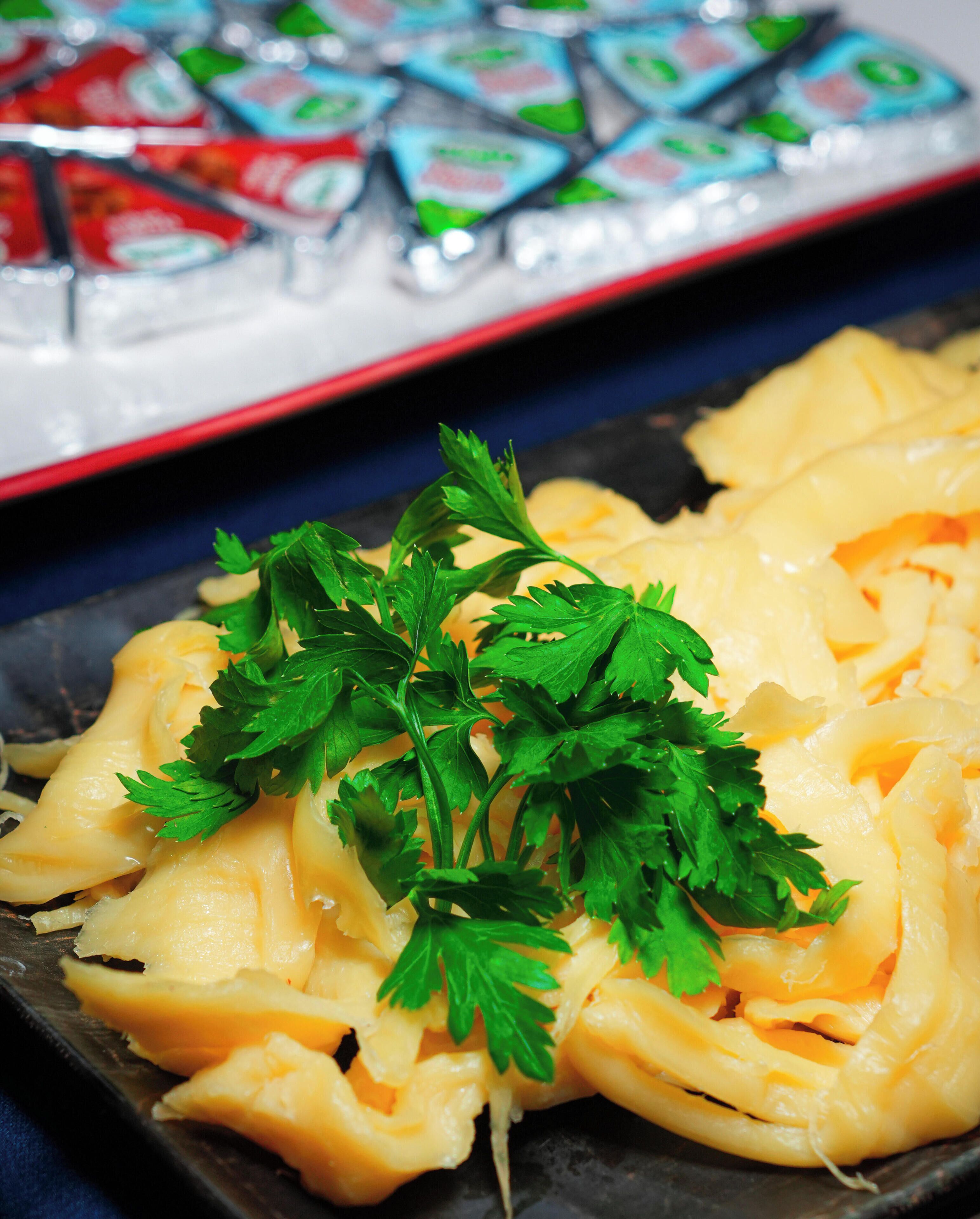 Ein Teller Pasta, garniert mit Petersilie, mit einer Sushi-Platte im Hintergrund.