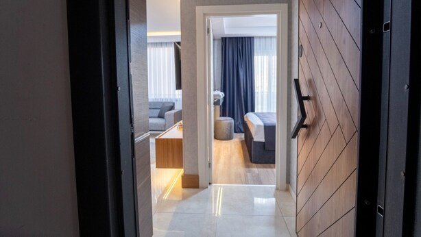 Una habitación de hotel moderna con una pared de madera, una cama, un sofá y una mesita.