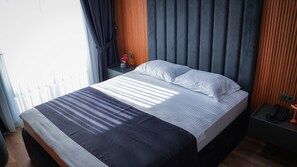 Ein Hotelzimmer mit einem Bett, einem Nachttisch mit Telefon und einer Nachttischlampe.