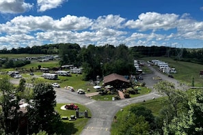 A campground with RVs, a central building, and surrounding greenery.