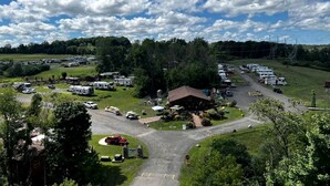 A campground with RVs, a central building, and surrounding greenery.